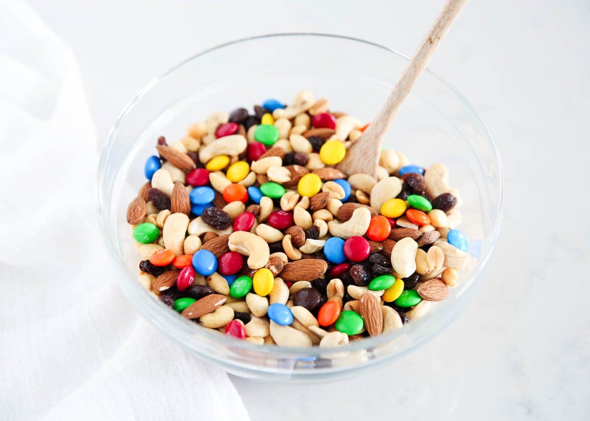 Trail mix with glass bowls with a wooden spoon. 