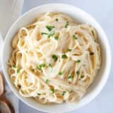 White sauce pasta in a white bowl.