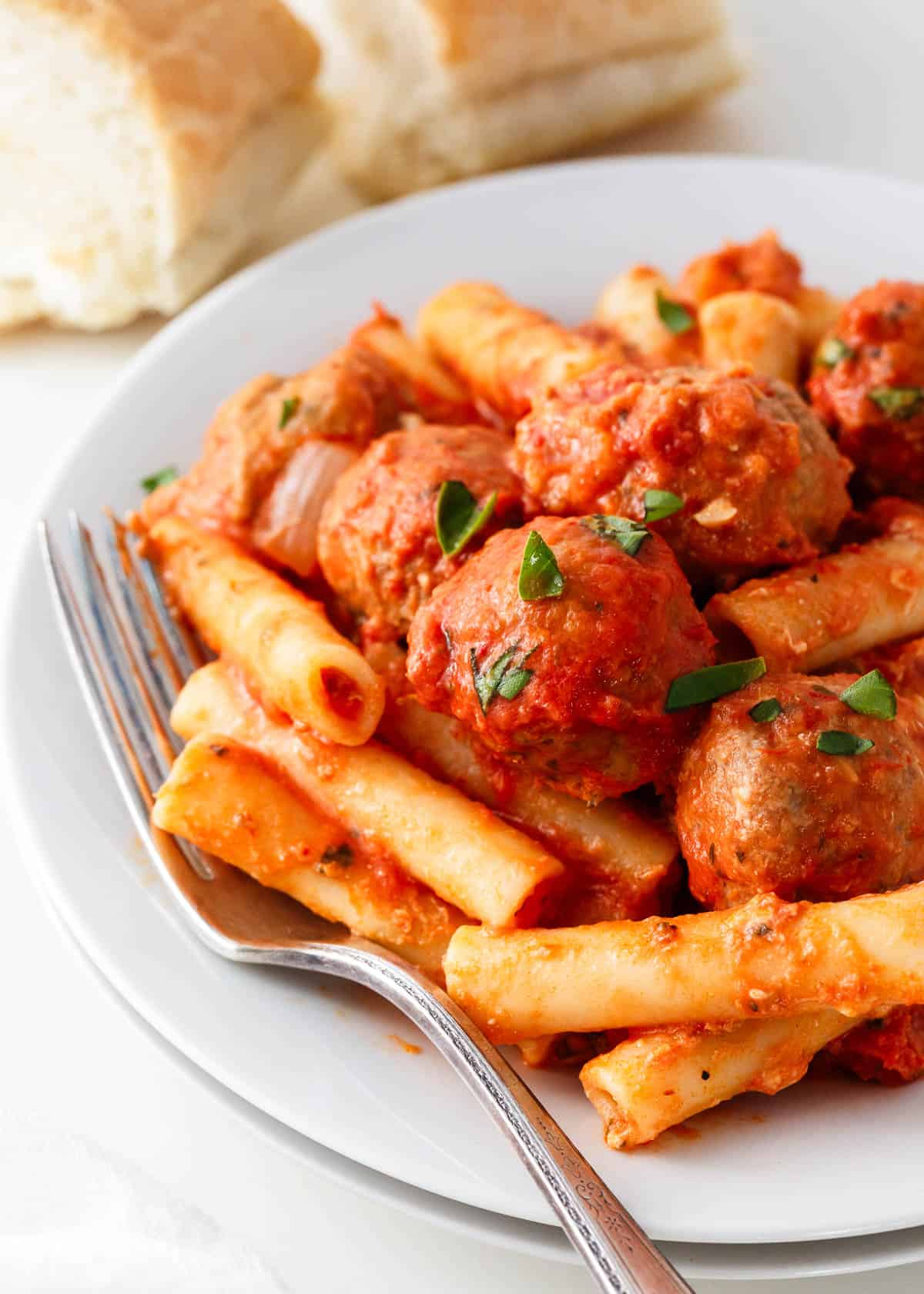Baked ziti with meatballs on a plate.