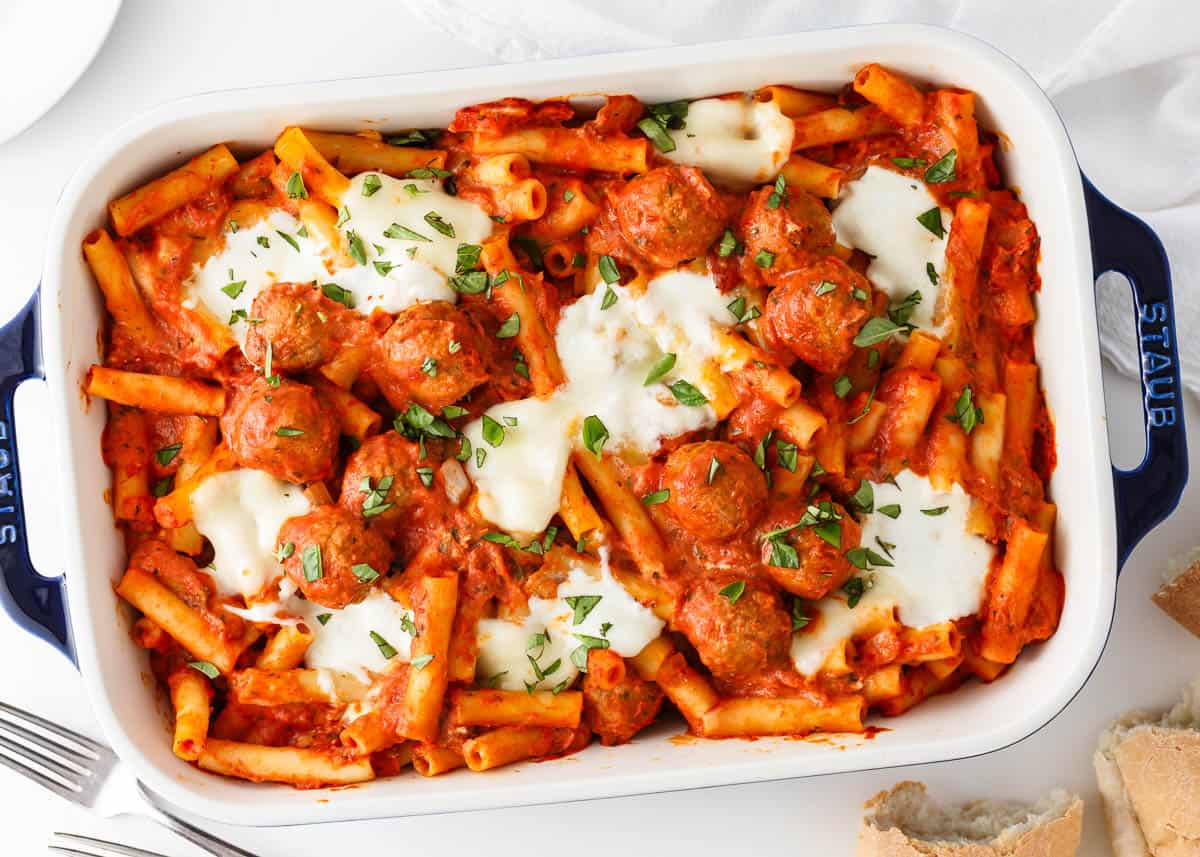 Baked ziti with meatballs baking in a casserole dish.