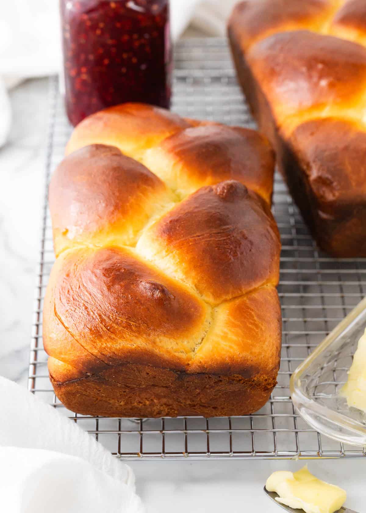 Braided brioche bread on cooling rack.