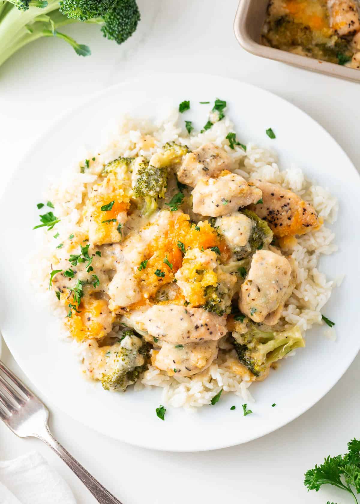 Chicken divan and rice on a white plate.