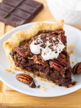 Slice of chocolate pecan pie on a white plate.