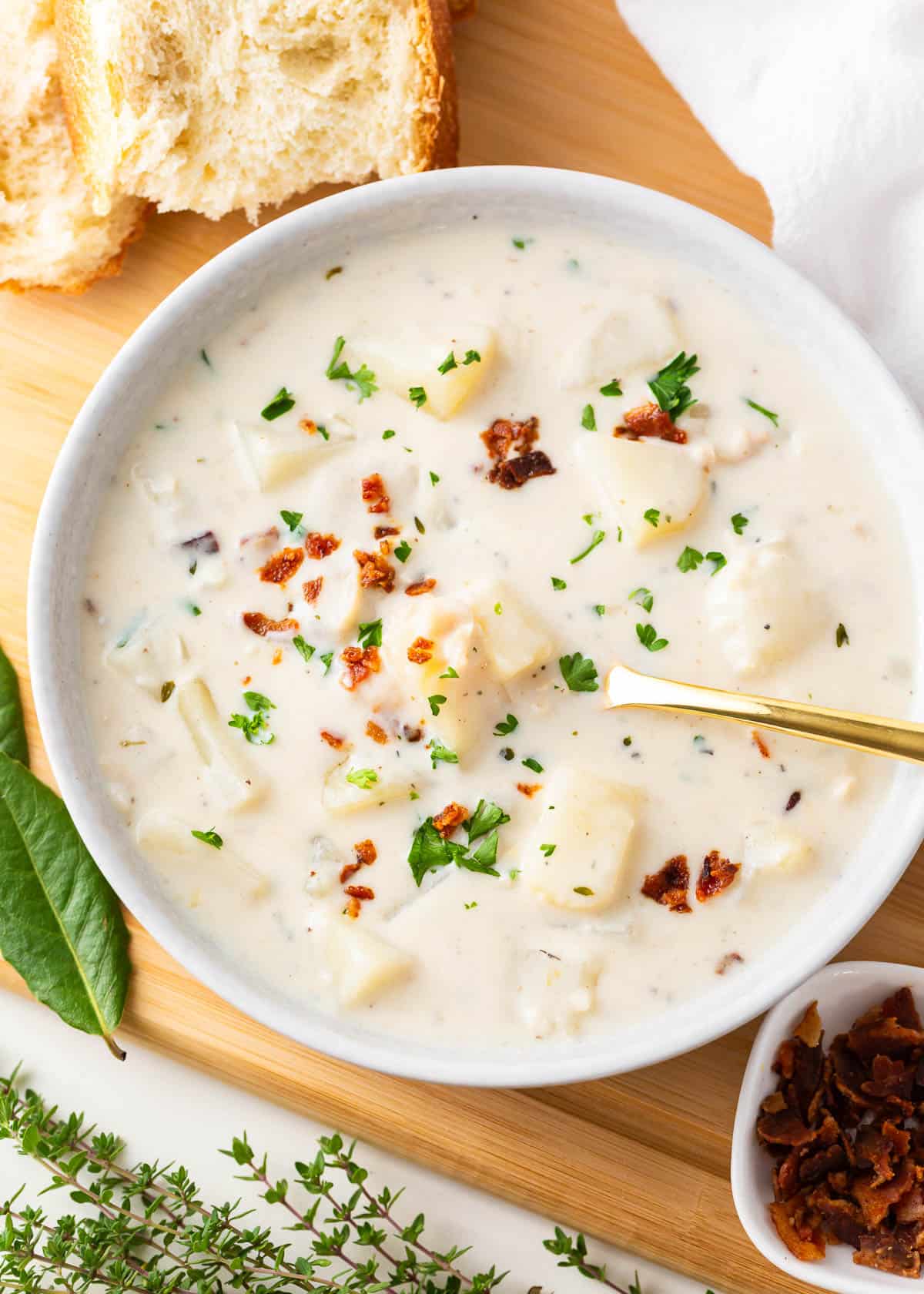 Bowl of clam chowder with toppings.