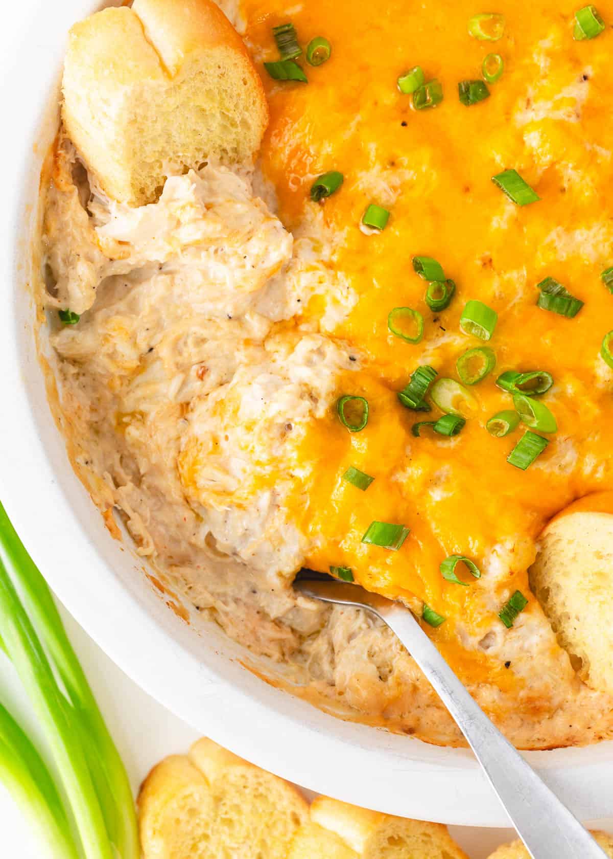 Make a crowd-pleasing bowl of the best hot crab dip and watch it disappear! Everyone loves the tangy, creamy dip - especially since it’s made with real crab! Spoonful of crab dip in pan.