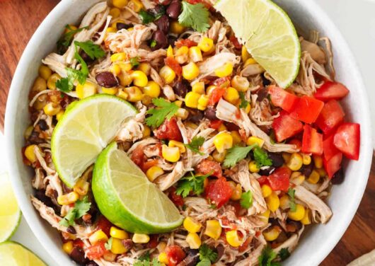 Crockpot Mexican chicken in a white bowl.