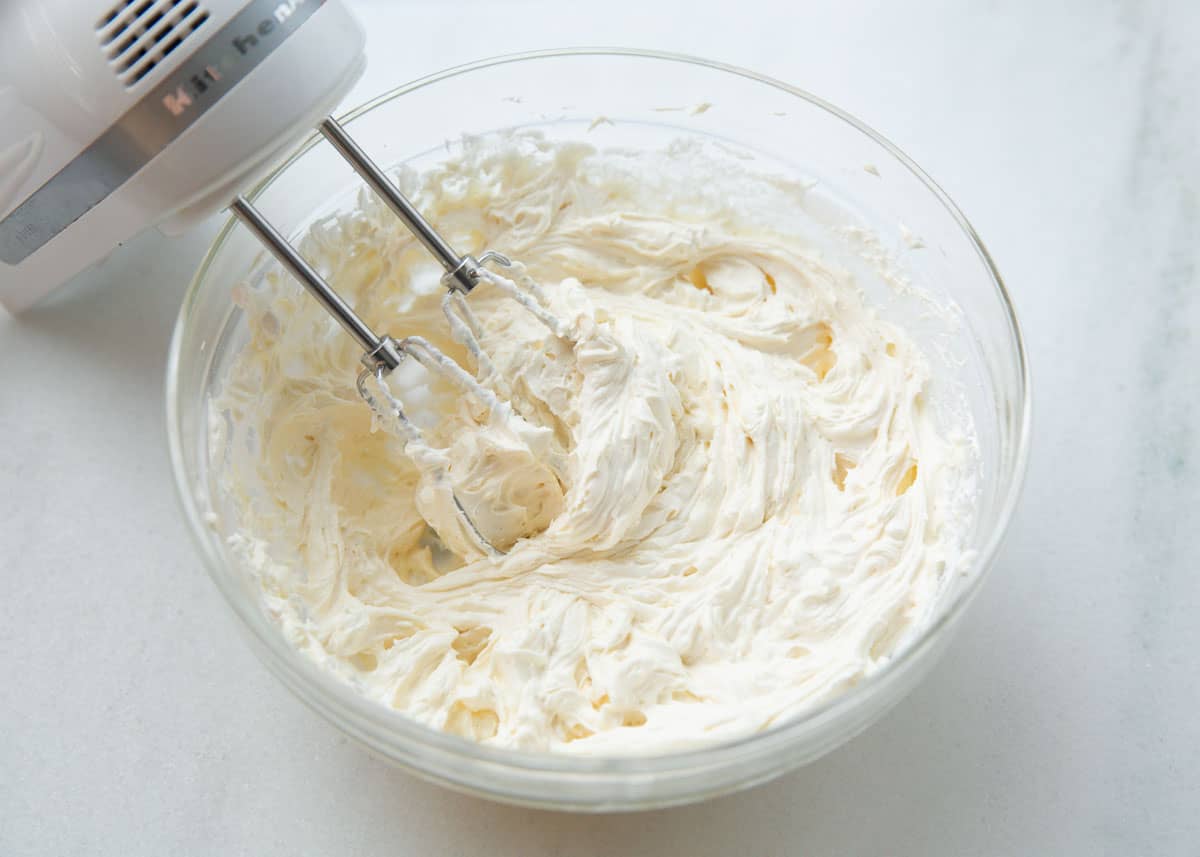 Mixing cream in a glass bowl. 
