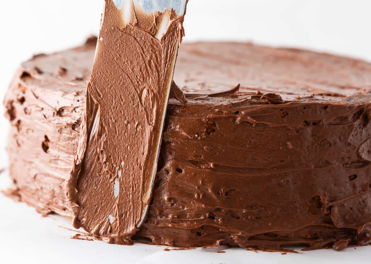 Spreading chocolate frosting onto a cake.