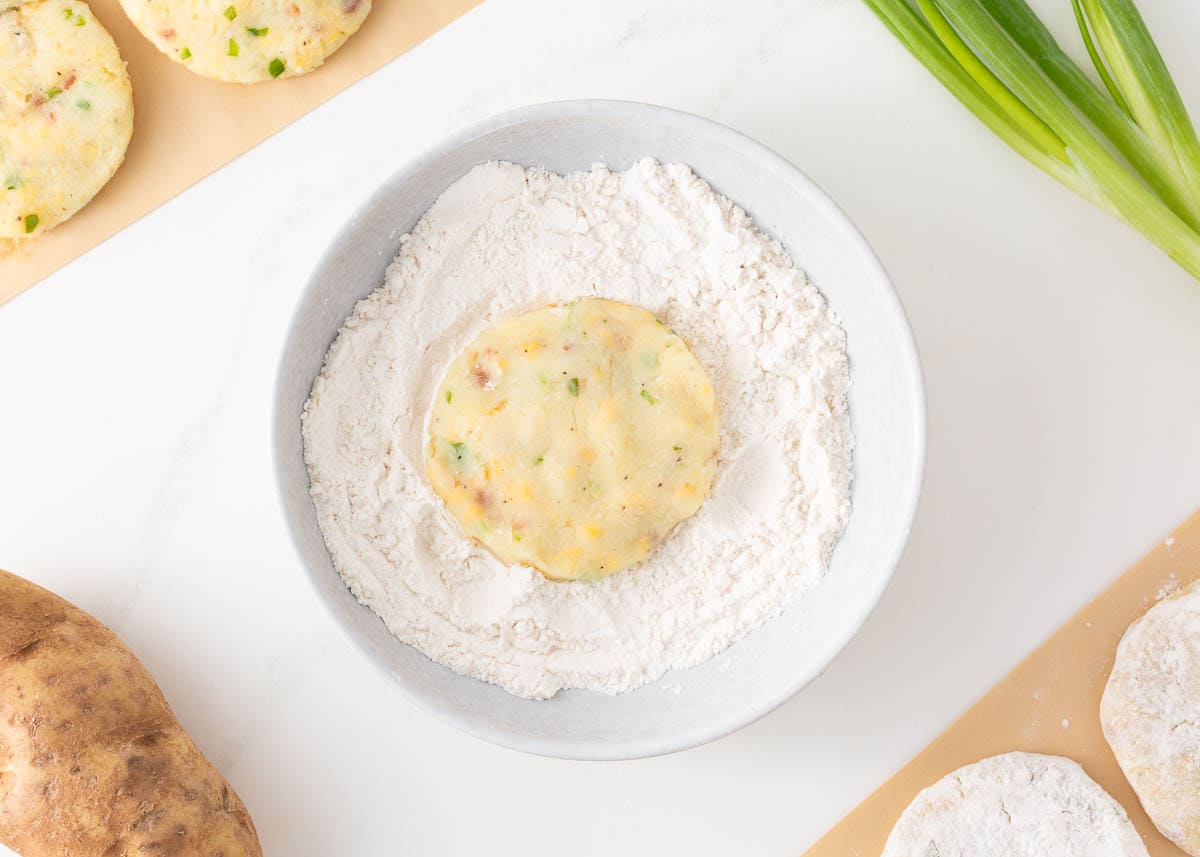 Dipping potato pancake in flour. 