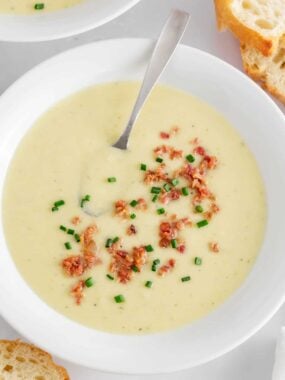 Potato leek soup in a white bowl.