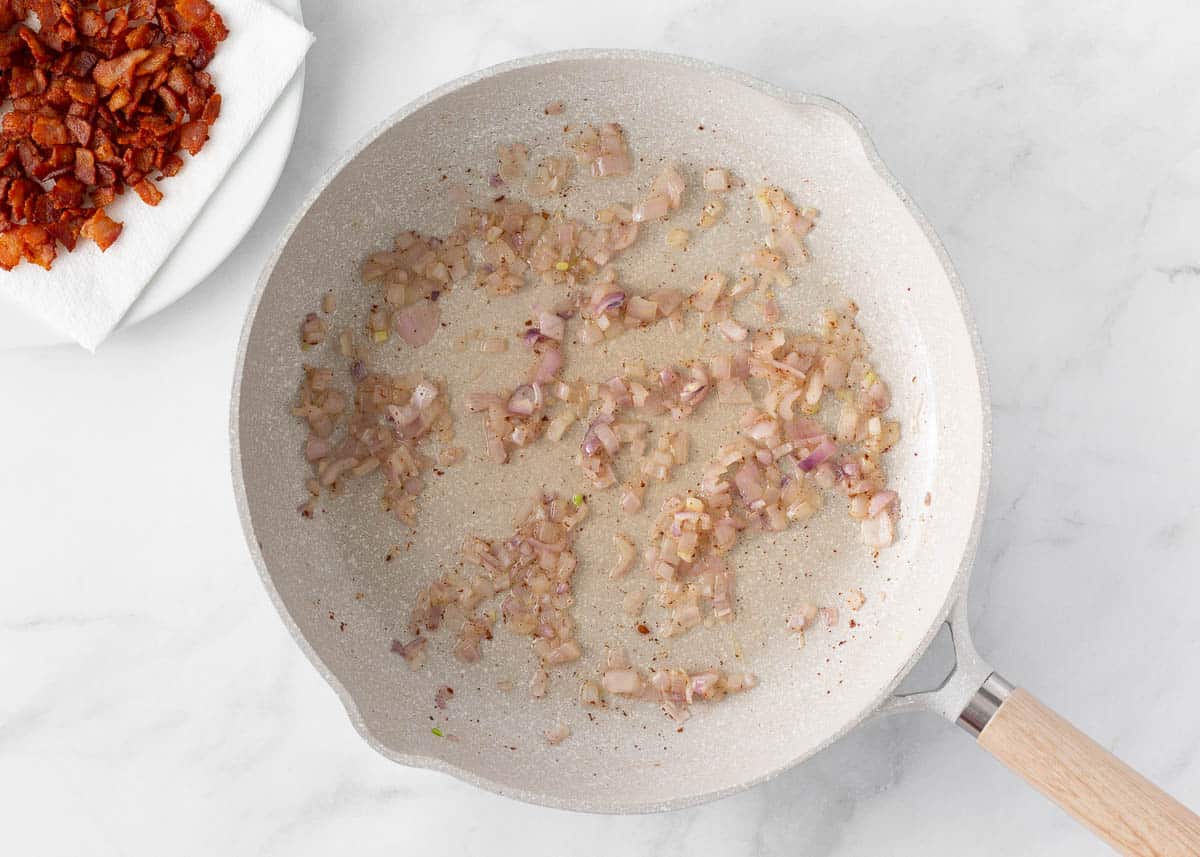 Bacon cooking in a skillet.