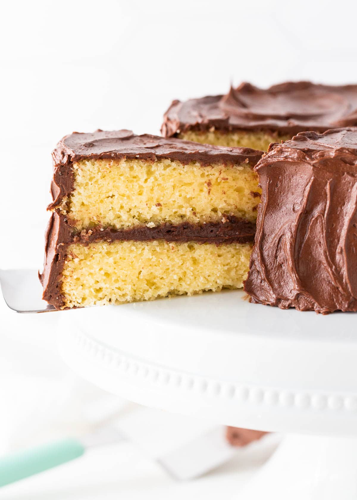 Slice of yellow cake on a cake stand.