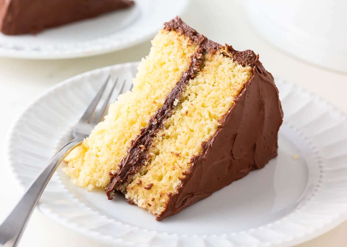 Slice of yellow cake on a white plate.