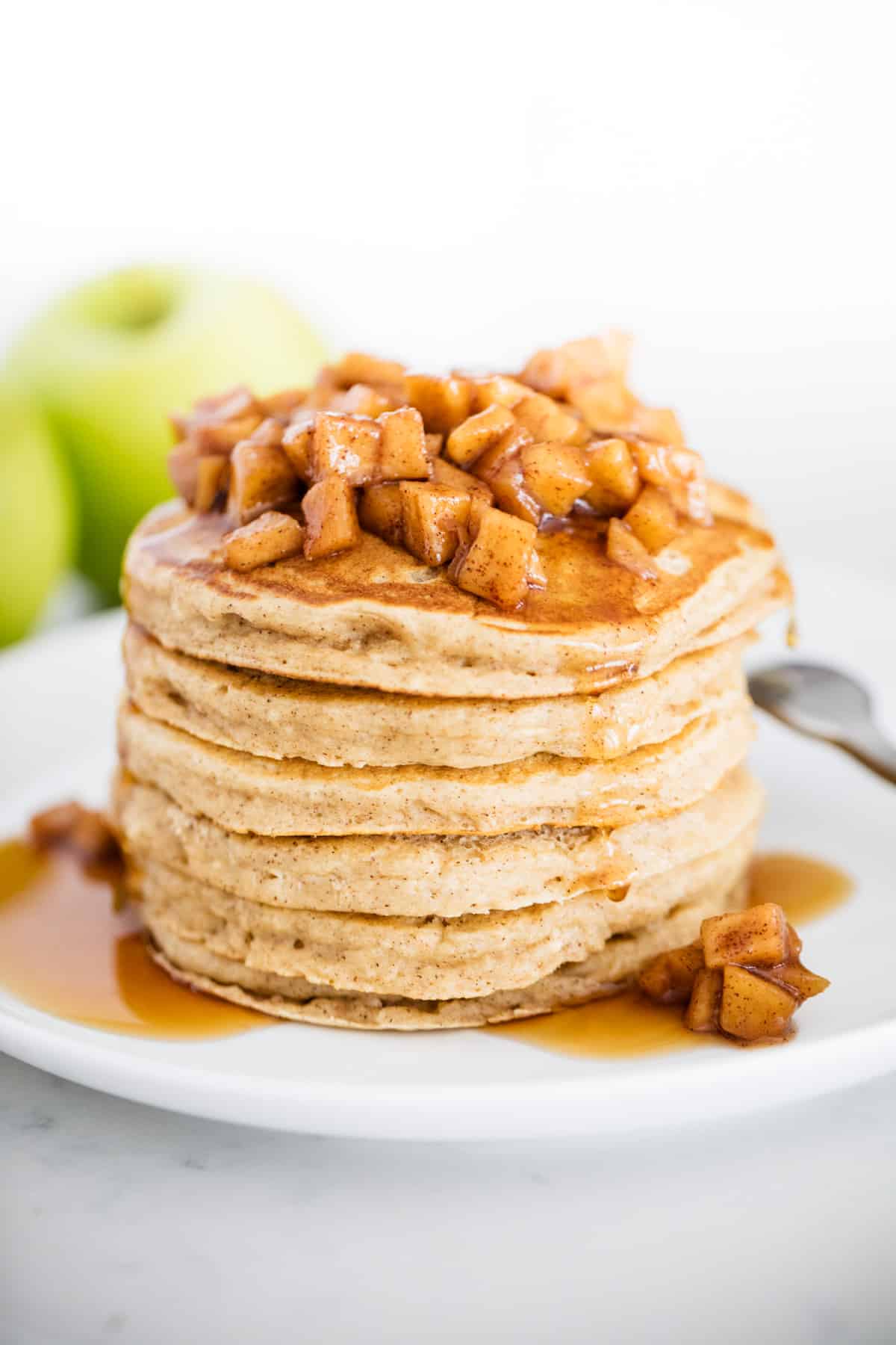 Stack of apple pancakes on a white plate. 