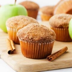 Apple muffins on a wooden cutting board.