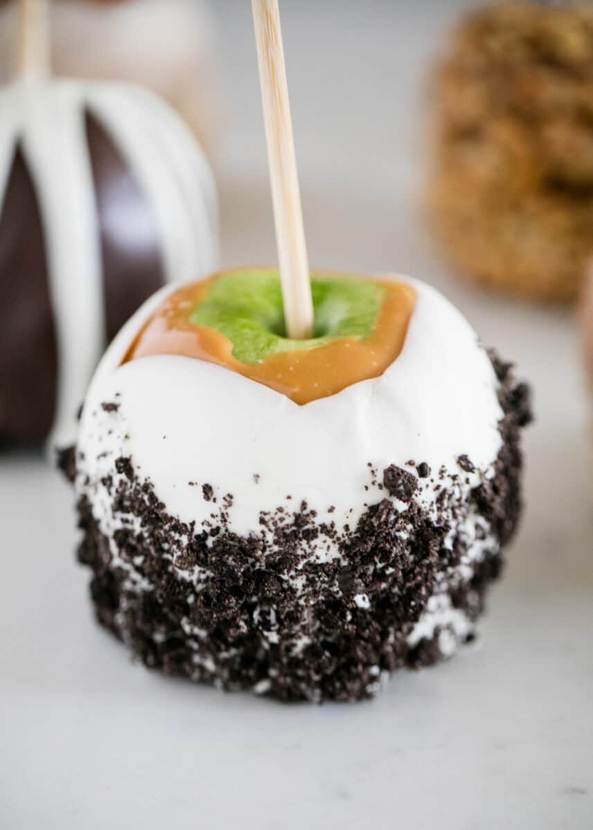 Caramel apple with chocolate on counter.