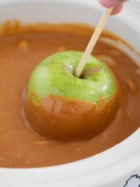 Dipping apple into caramel.