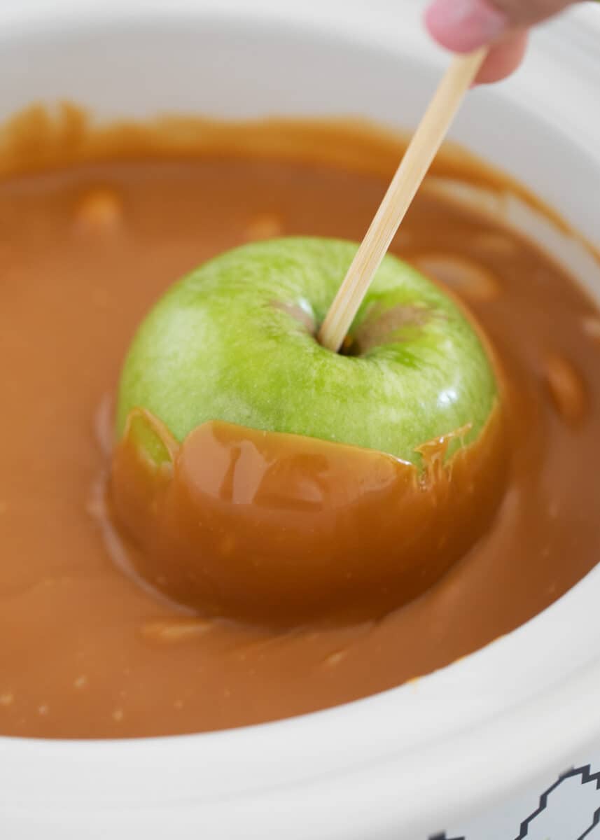 Dipping apple into caramel.