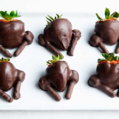 Chocolate covered strawberry turkeys on plate.