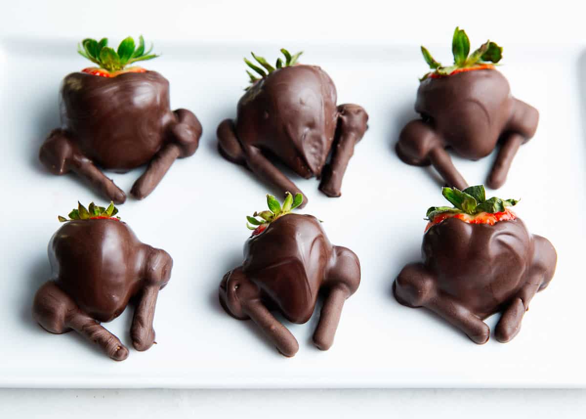 Chocolate covered strawberry turkeys on plate.