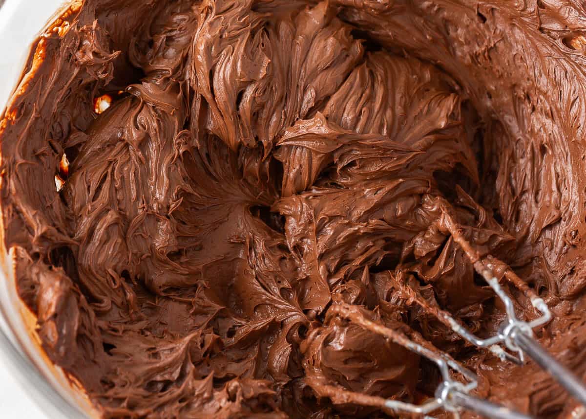 Mixing chocolate frosting in a bowl.