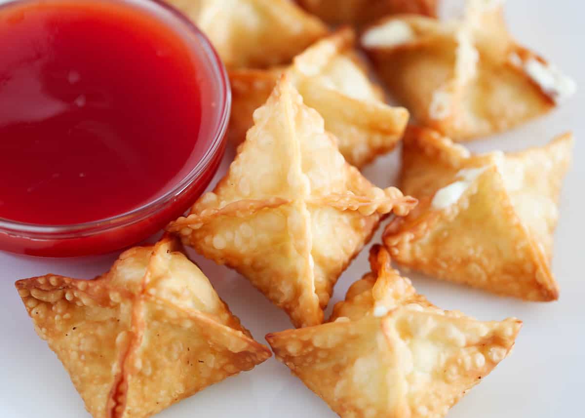 These cream cheese wontons are a time and money-saving homemade version of your favorite Panda Express takeout item! They're the perfect appetizer for parties and family movie nights served with a side of sweet and sour sauce! Cream cheese wontons with sweet and sour sauce.