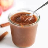 Apple butter in a jar with spoon.