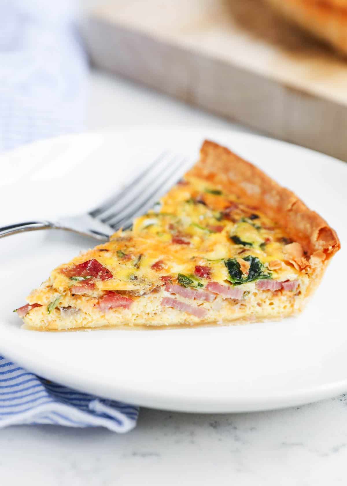 Slice of quiche on a white plate.