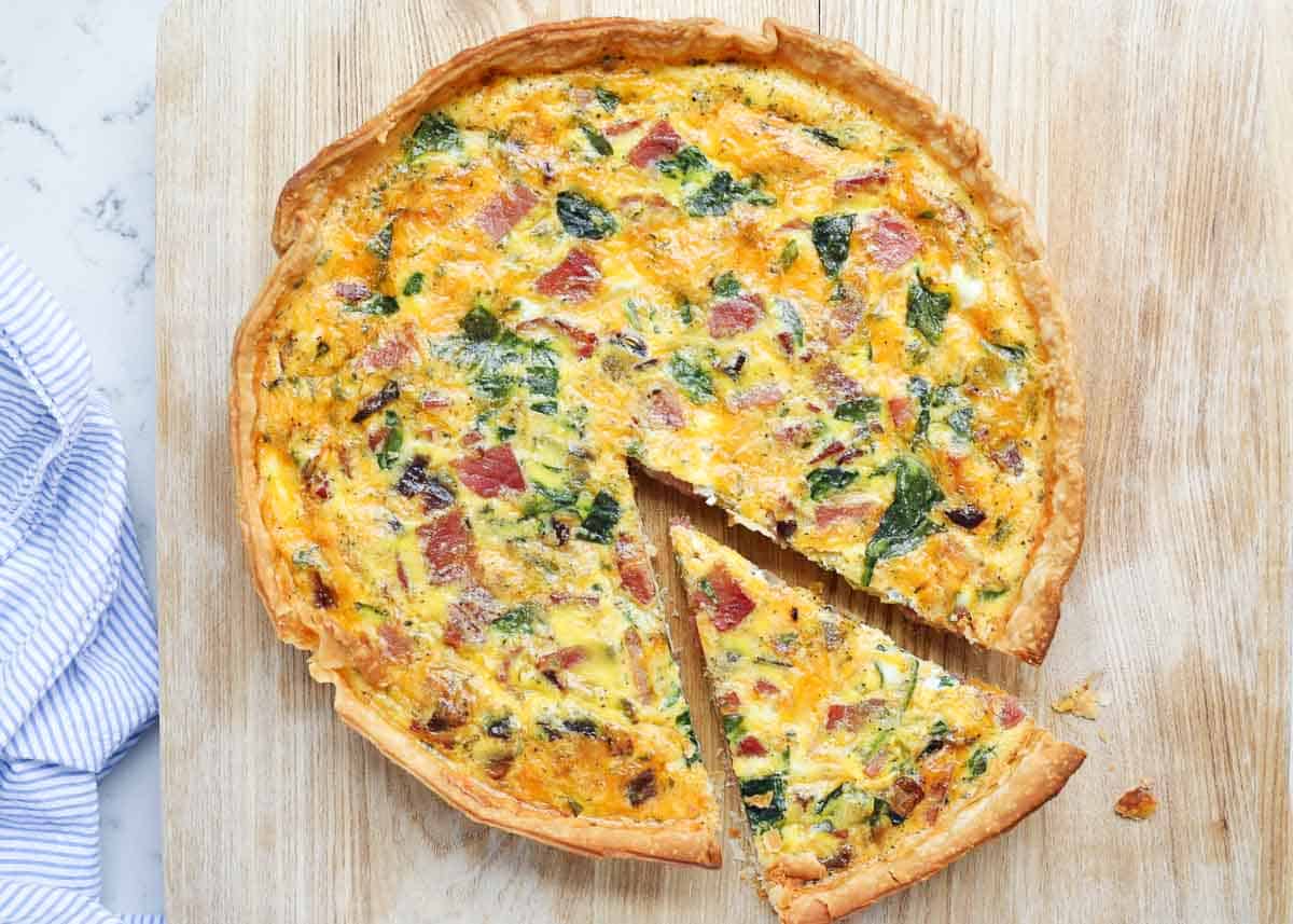 Sliced ham quiche on a board.