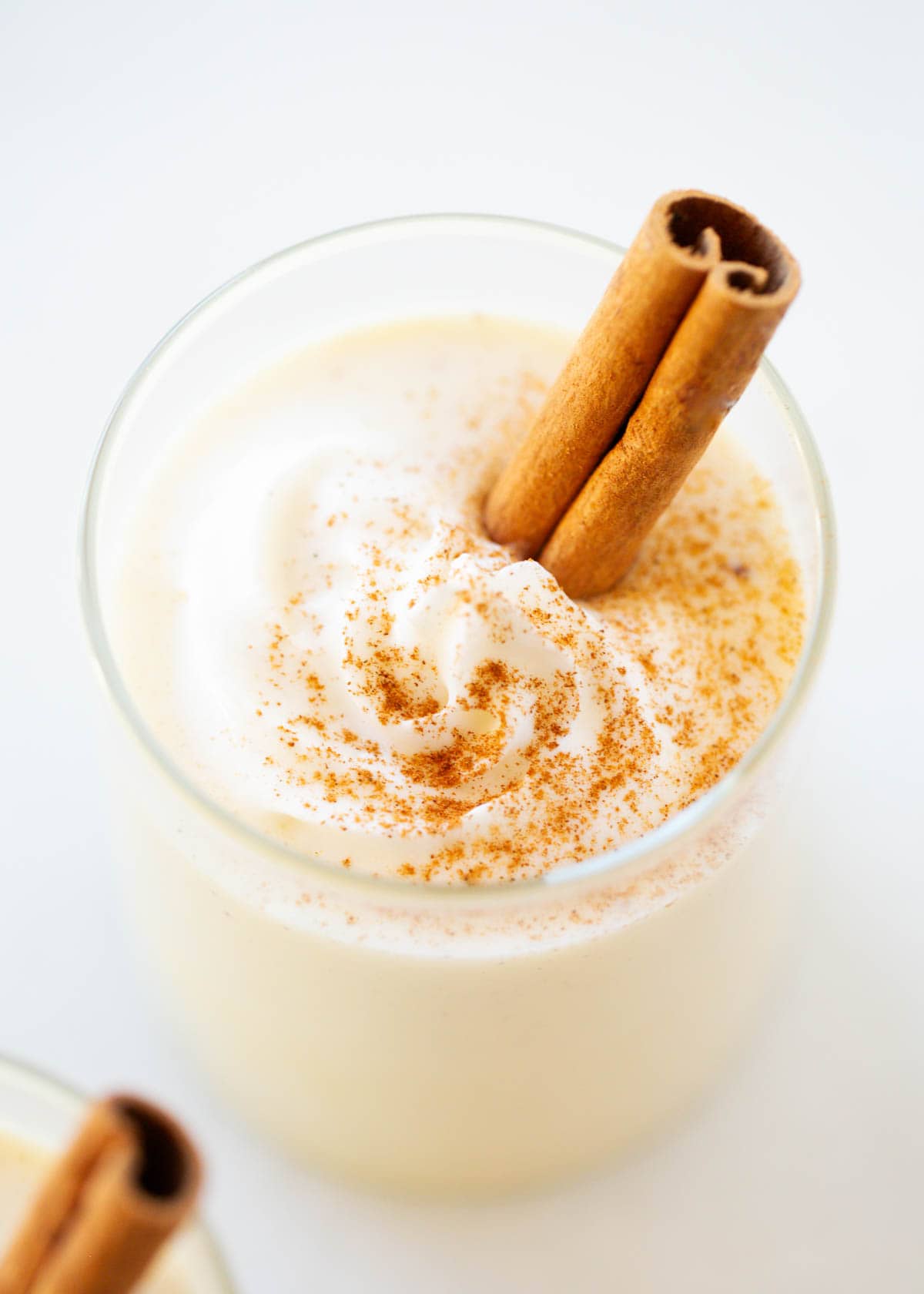 Eggnog in a cup with a cinnamon stick.