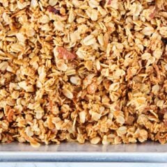 A pan of homemade granola with crunchy clusters of oats, nuts and coconut.