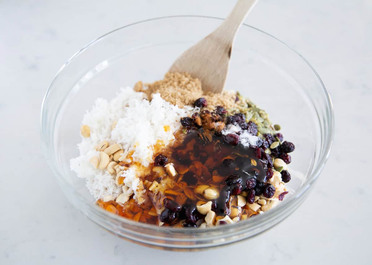 Oats, coconuts, nuts and sweetener in a bowl.