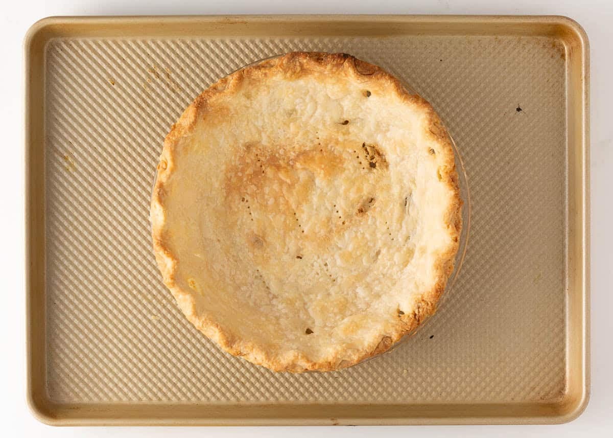 Blind baked pie crust in a pie dish on a sheet pan for homemade lemon meringue pie.