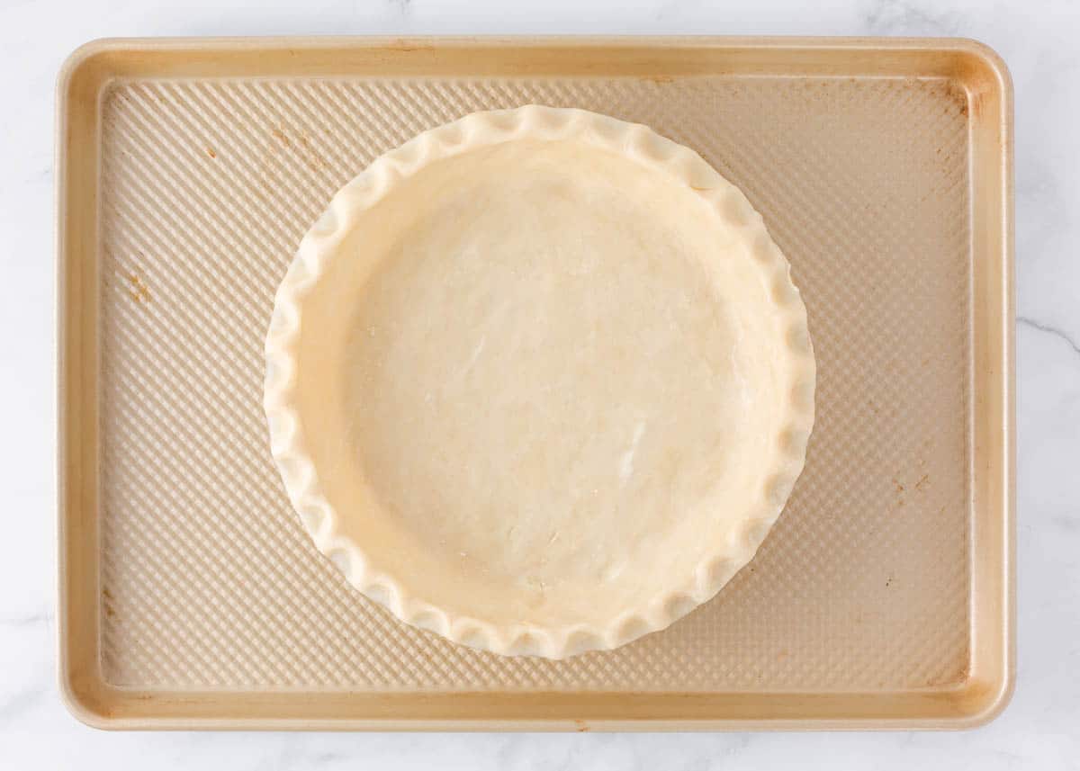 Unbaked pie crust on a baking sheet.