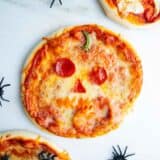 Jack o lantern pizza on a counter.