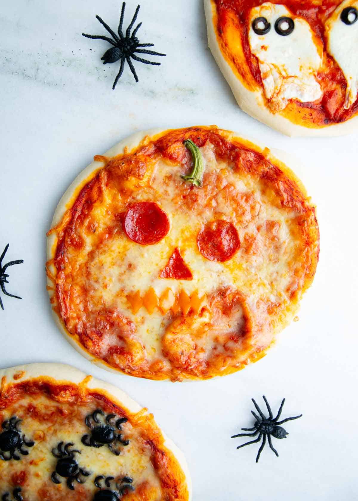 Jack o lantern pizza on a counter.