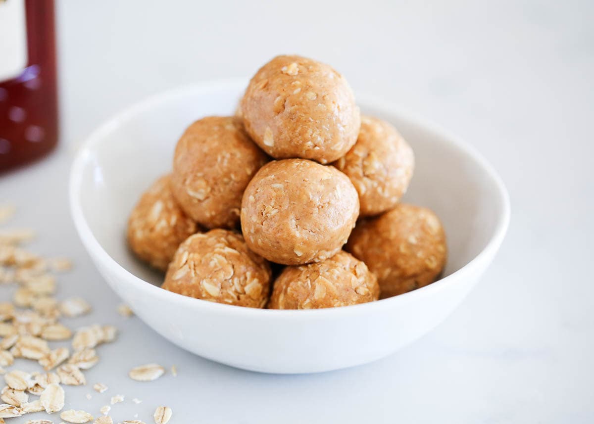 Peanut butter oatmeal balls stacked on top of each other in a white bowl. 