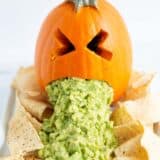 Puking pumpkin with chips on a plate.