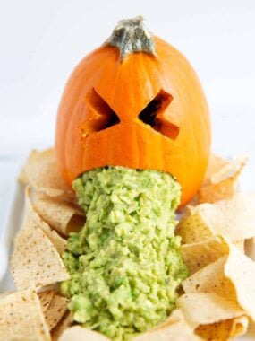 Puking pumpkin with chips on a plate.