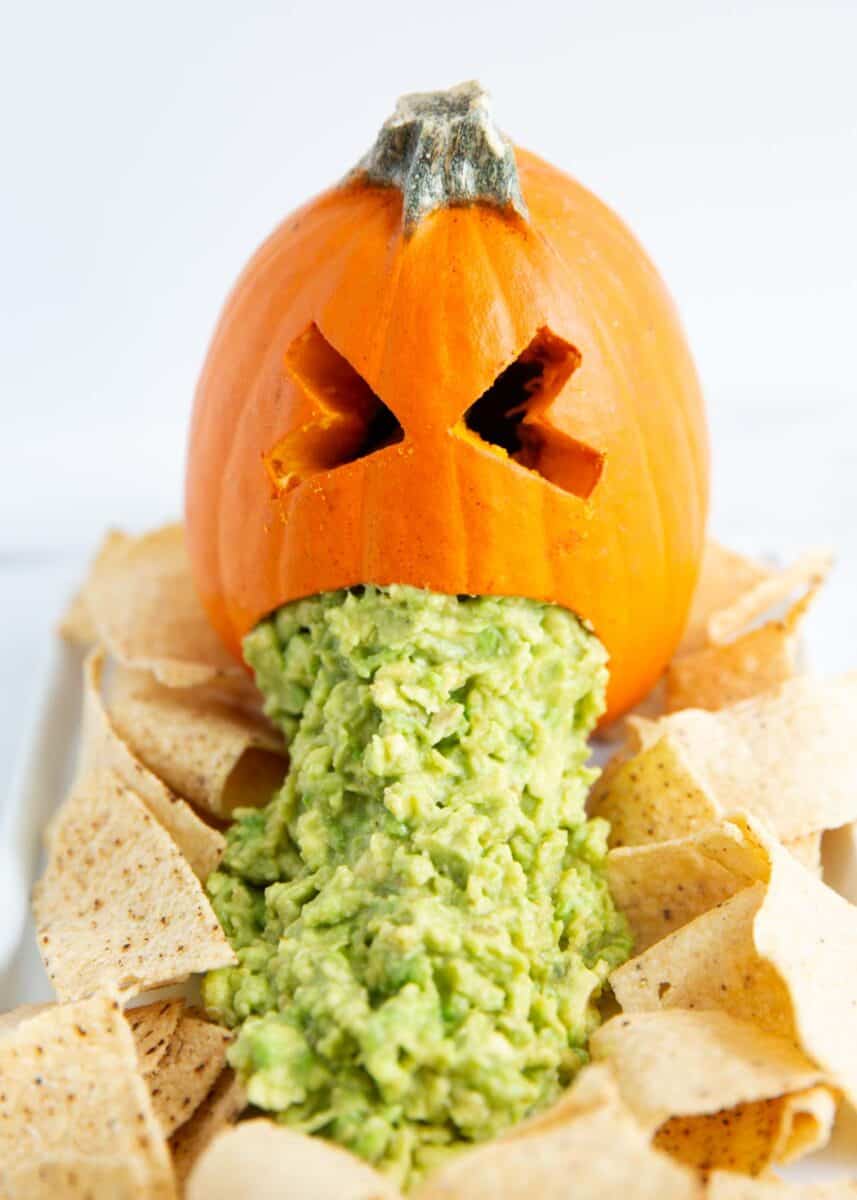 Puking pumpkin with chips on a plate.