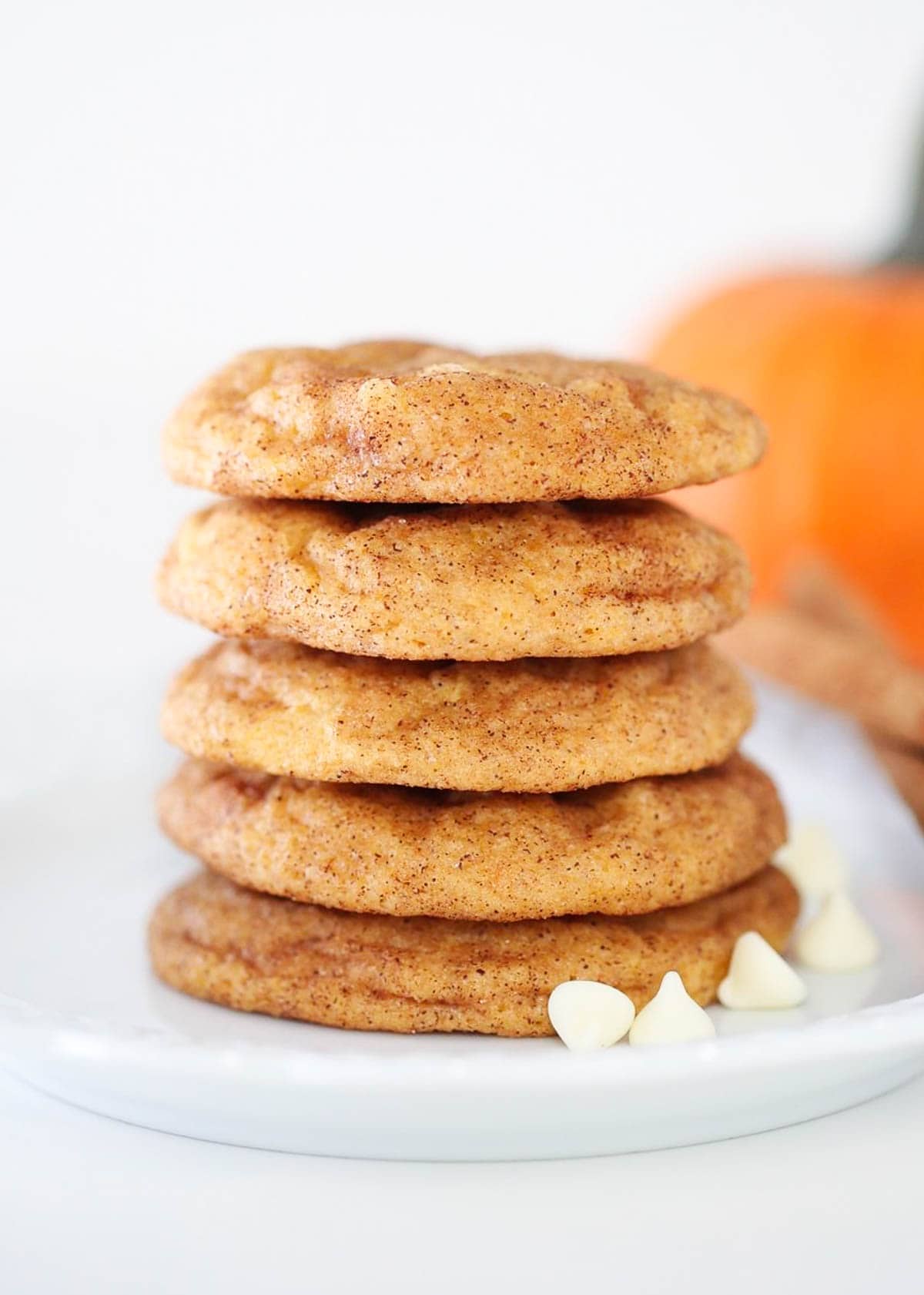 Stacked pumpkin snickerdoodles on a plate.