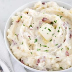 Mashed red potatoes in a bowl with butter.