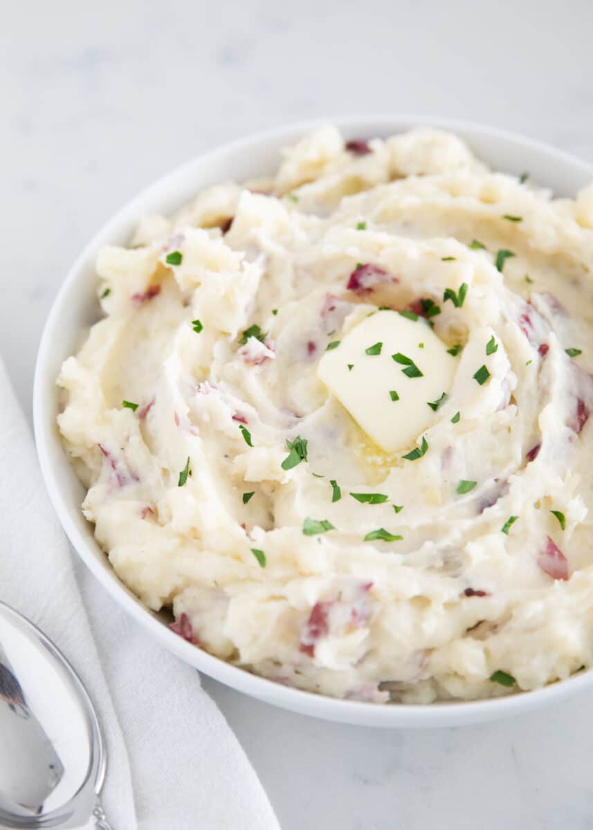 Mashed red potatoes in a bowl with butter.