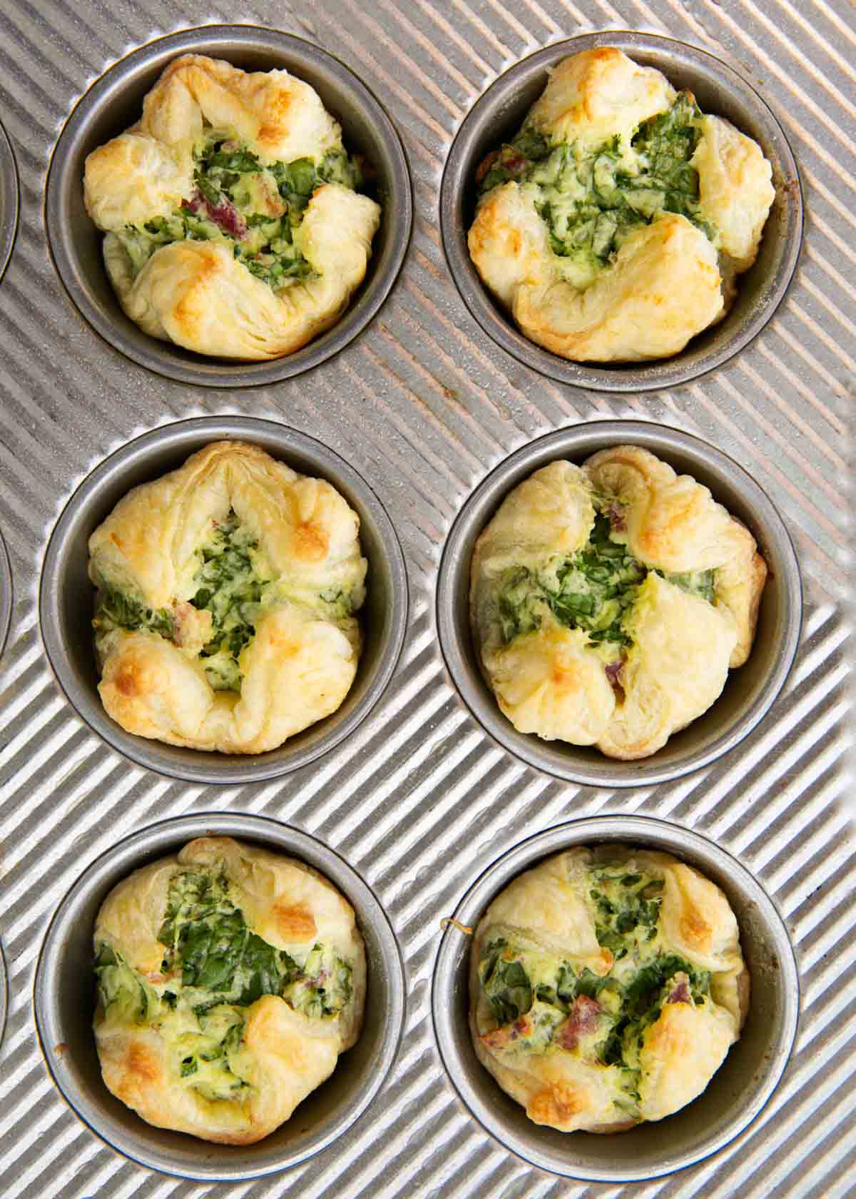 Spinach puffs cooked in a muffin tin.