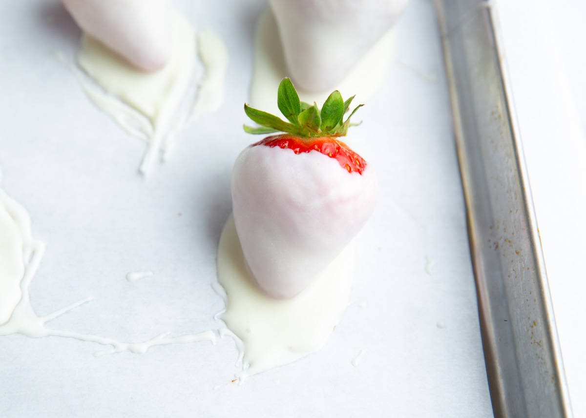 White chocolate strawberries on the counter.