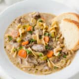 Beef noodle soup in a white bowl.