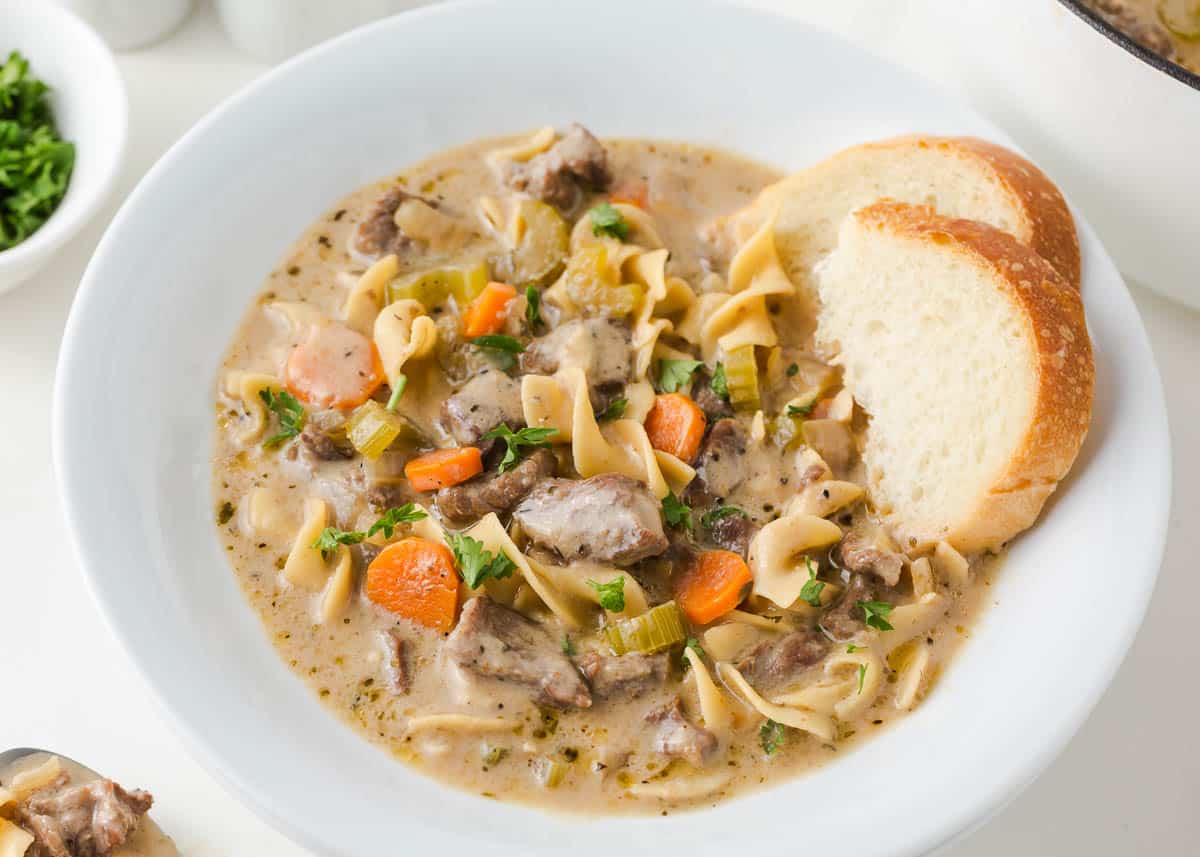 Beef noodle soup in a white bowl.