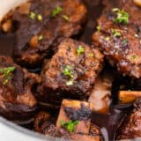 Juicy braised short ribs cooking in a pot.