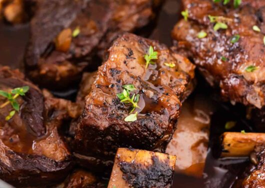 Juicy braised short ribs cooking in a pot.