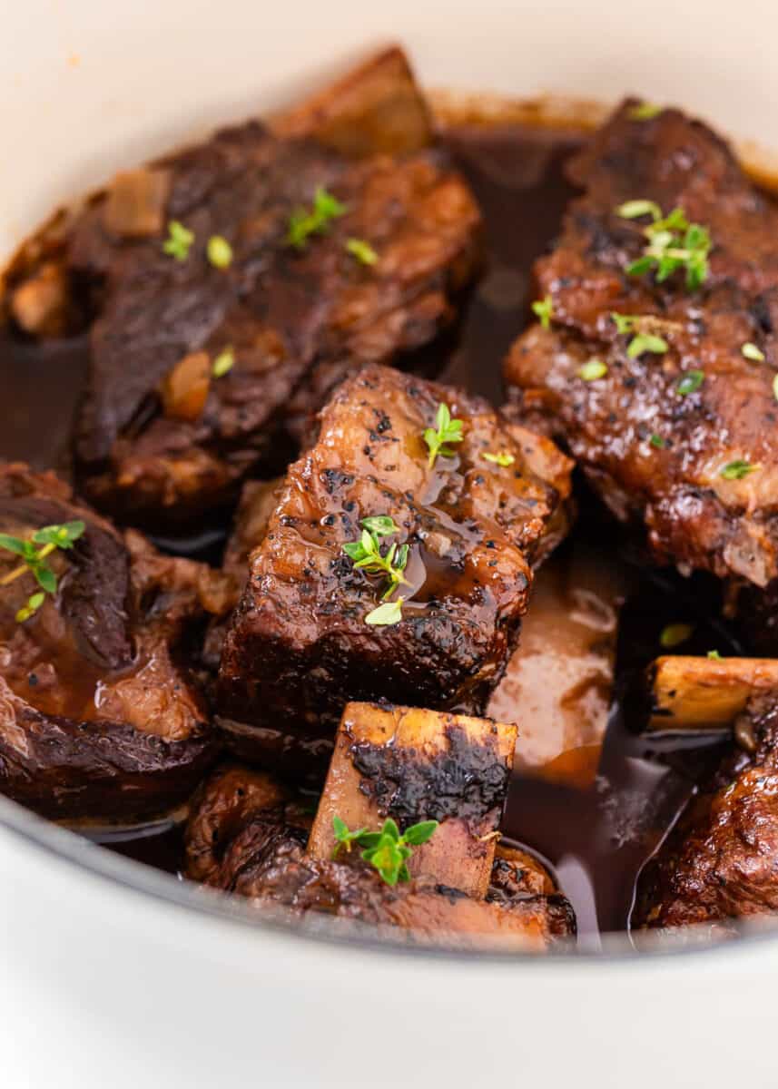 Juicy braised short ribs cooking in a pot.